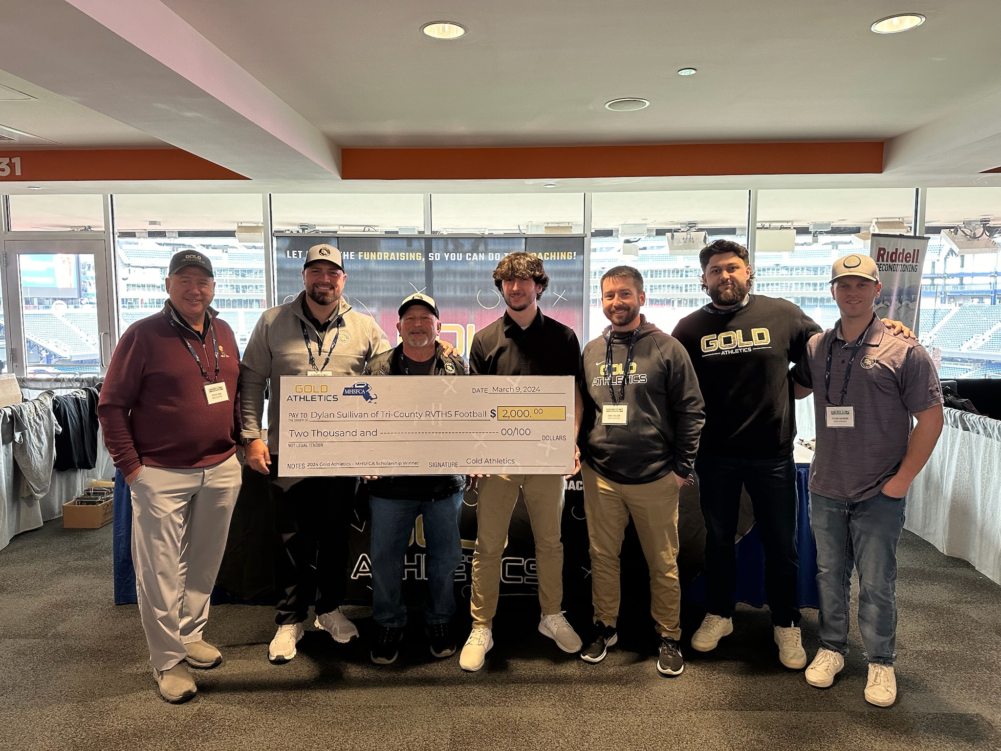 The Gold Athletics team holds a big check for Leadership Scholarship recipient Dylan Sullivan of Tri-County RVTHS Football in 2024