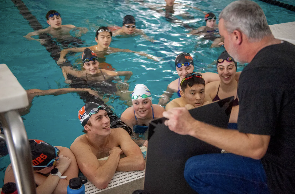 Wayland High School Swim Coach Mike Foley with athletes in the Wayland pool