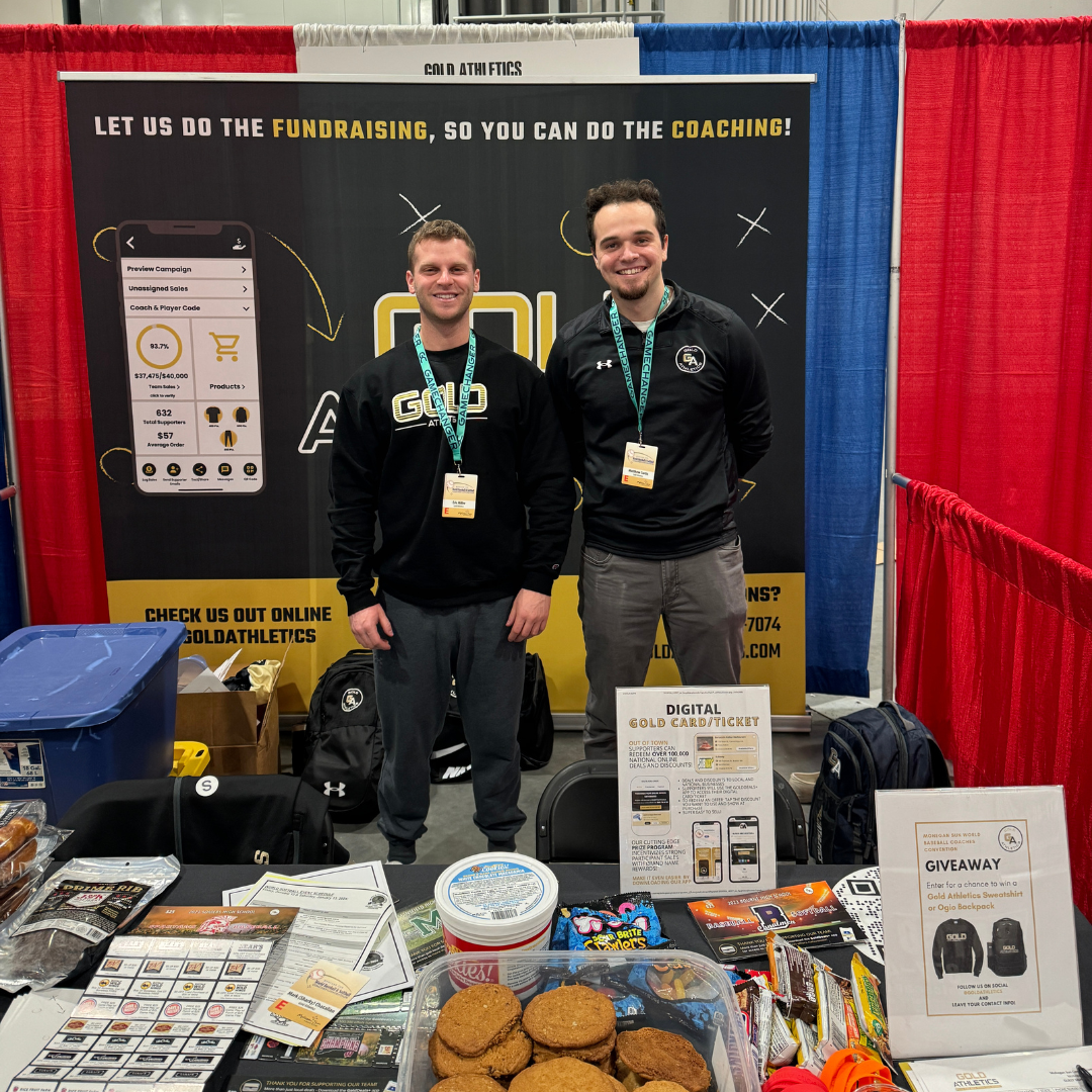 Tyler Morini and Matt Curtis at a GoldAthletics clinic booth with backpack giveaway and cookie fundraiser samples. 2024.