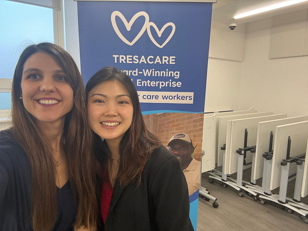 Ale and Liz smiling in front of our Tresacare job fair stand