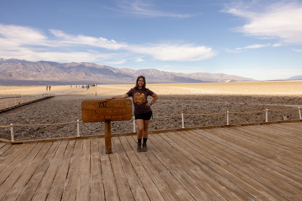 A woman standing next to the Badwater Basin sign in Death Valley National Park