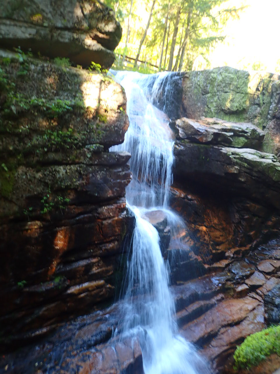 A waterfall cascades over rocks creating a serene scene