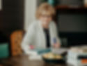 linda at table writing on flip chart paper crop landscape.jpg