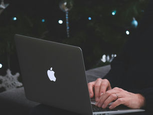 hands types on laptop