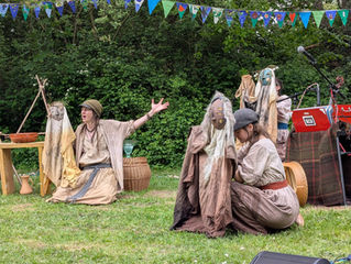 Kestrel storytelling holding Rheidol puppet while the other two puppets are held by musicians