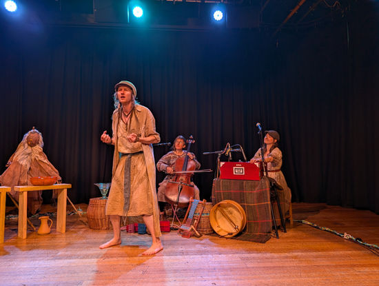Kestrel storytelling with 1 puppet on the left and musicians behind