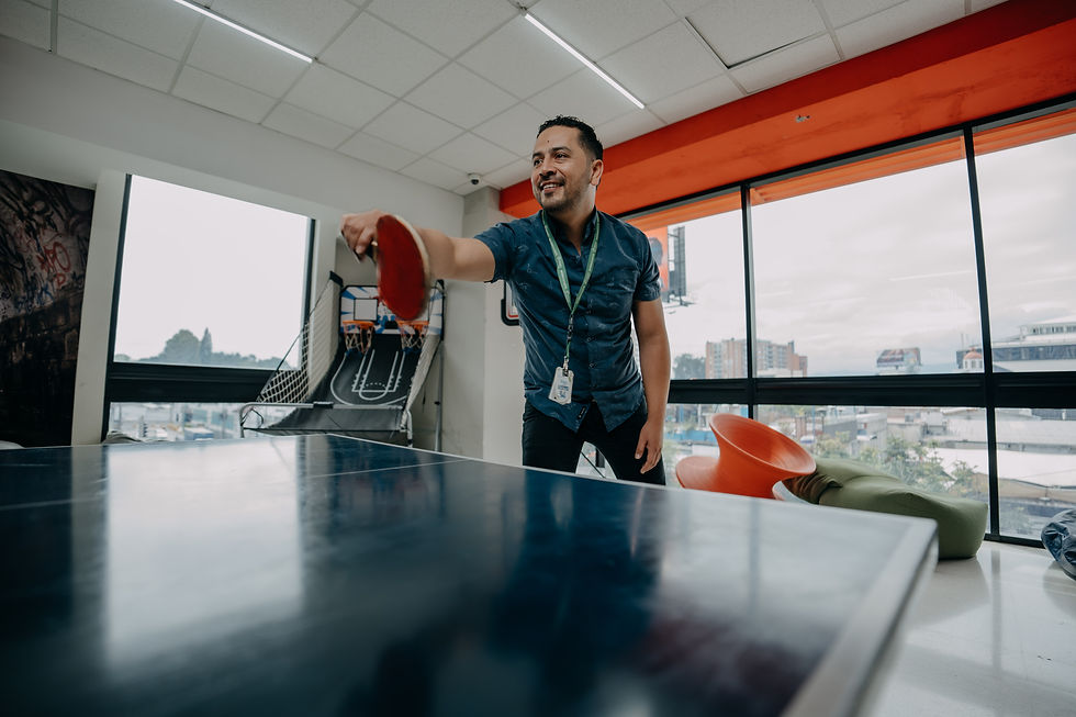 Smiling man playing ping pong in an office