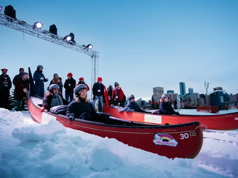 Flying-Canoe-Volant_A-group-get-ready-to-race-down-a-snowy-hill-in-red-canoes-at-night-1-s