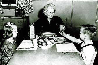 Former Executive Director Margaret Brooks teaches children at Bethany Home the fine points of table manners.