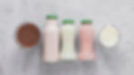 A variety of flavored dairy beverages in bottles and jars.