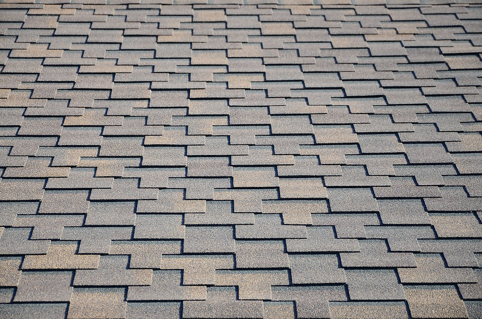 Close-up view of textured grey and tan asphalt roof shingles.
