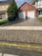 Image of a beautifully maintained interlocking paver patio with clean, sanded joints. The pavers are sealed, giving them a vibrant and polished appearance, while the polymeric sand between the joints is intact, preventing weed growth and ensuring stability