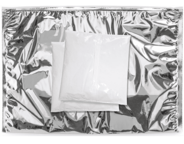 Picture of a silver thermal foil pouch with white cold-storage soft gel packs place on top.