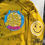 Thumbnail: Dandelion with black tie dye hoodie with smiley faces on torso and sleeve