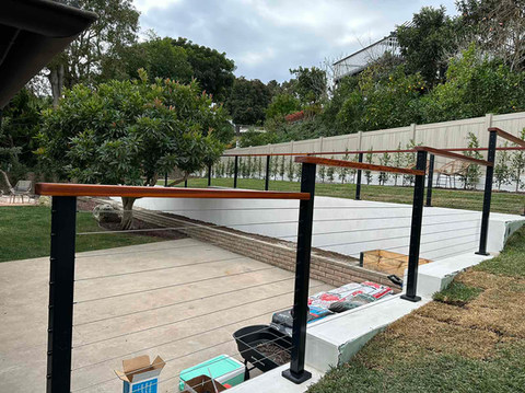 Aluminum cable railing with stainless steel cables and hardwood handrail top. By Torrance Fence Company