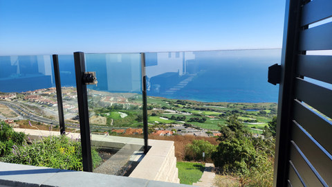Aluminum and glass railing on residential balcony with clear ocean  view. High - grade 6063 aluminum alloy. By Torrance Fence Company