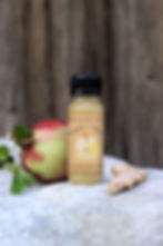60 ml Flasche Ingwer-Shot mit Bio Apfelsaft, regional hergestellt in der Schweiz, ohne Zuckerzusatz neben Apfel