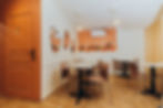 Espace de tables avec plateaux effet terrazzo et chaises rose poudré dans un salon de th