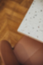 Détail de tables effet terrazzo et de chaises rose poudré dans un salon de thé à Valence.