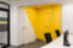 Détail coloré et signalétique décorative menant aux toilettes des bureaux Syntonize.