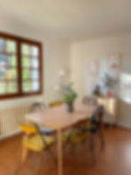 Salle  à manger avec chaises vintage, décoration moderne et plantes.