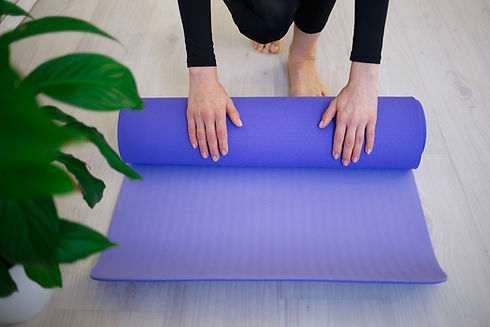 young-woman-unfolds-yoga-mat-before-practice-2021-09-01-19-12-39-utc.jpg