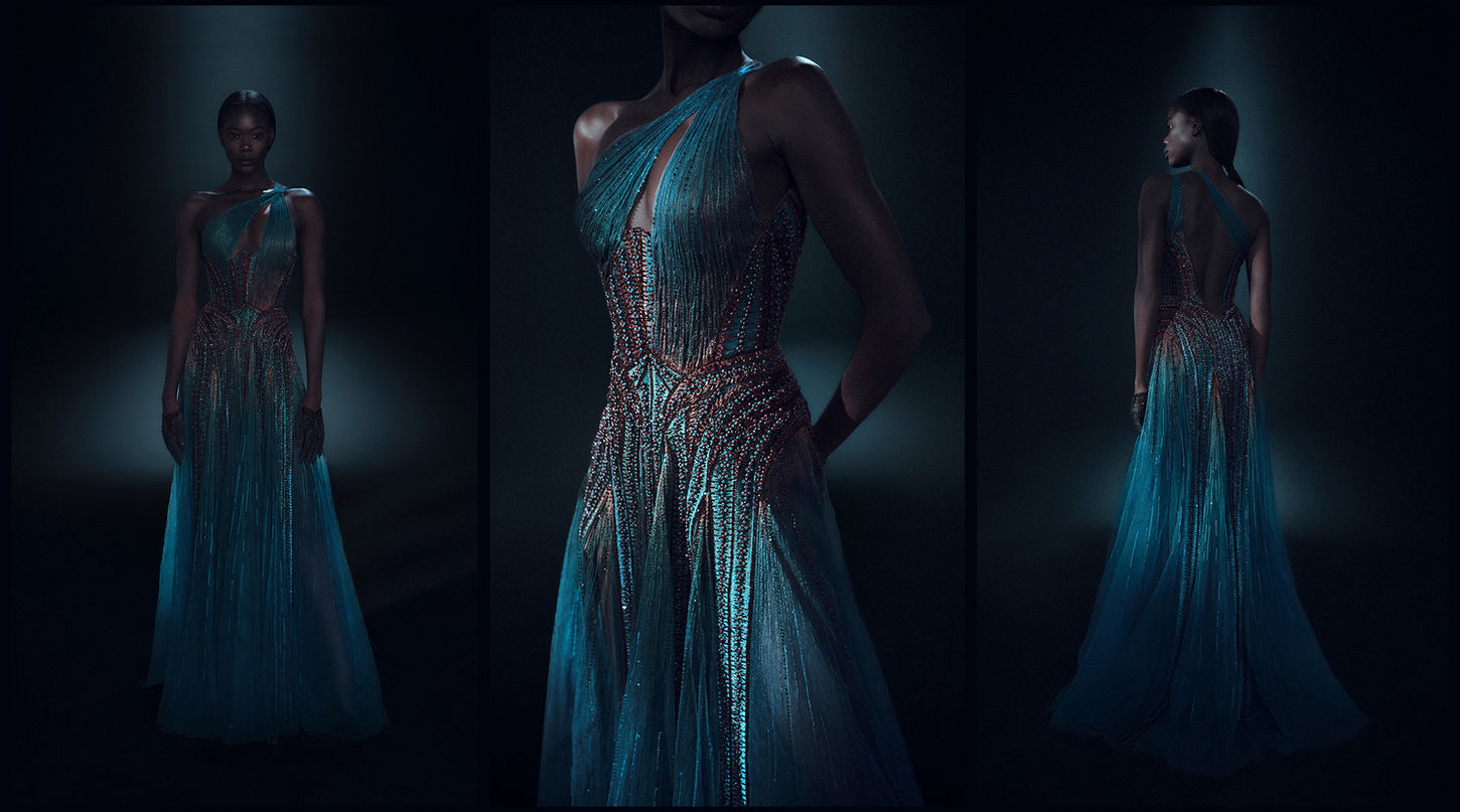 An African female model showcasing a hand-embroidered, one-shoulder Hassidriss dress made of blue and green tulle.