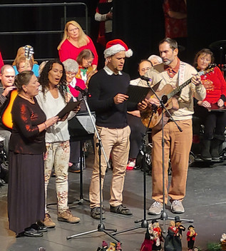 A group of 4 performing a song wiith a guitar