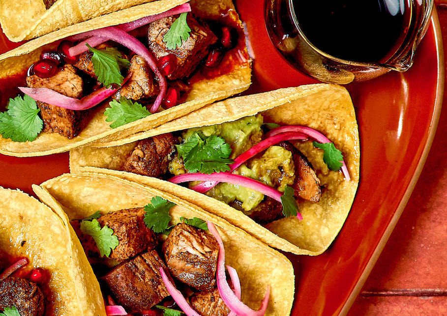 Street-style tacos with pickled onions and lime photographed with bold color and editorial styling.