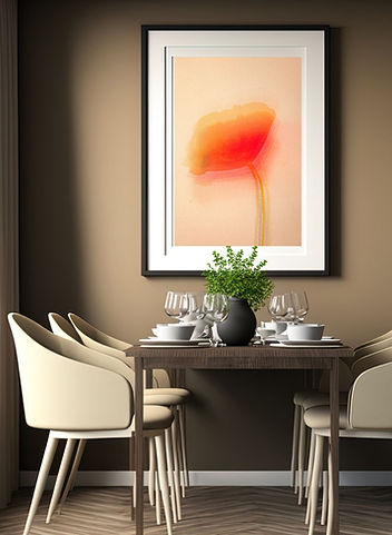 A framed fine art print of an abstract poppy flower in warm red, orange, and gold tones against a soft blush background, displayed above a modern dining table in a neutral-toned room.