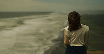 A rear view of a woman looking at the shore line