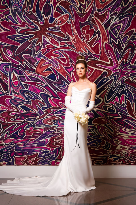 bride standing in front of a wall art
