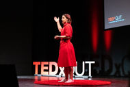 Leanne red dress on TEDx QUT Stage