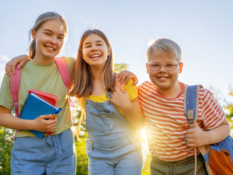 Drei Kinder lächeln in die Kamera