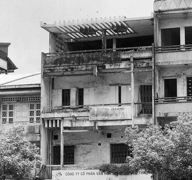 Mid-century Vietnamese modernist shophouse with pergola roof and concrete façade in Saigon, illustrating vernacular adaptations of modernist architecture along a busy urban street