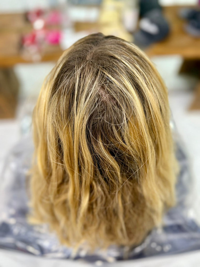 Vorherbild einer stark herausgewachsenen Balayage mit dunklem Ansatz, warmen Gelb- und Orangetönen sowie fleckigem Blond, aufgenommen im Friseursalon in Konstanz Altstadt am Bodensee, Haare trocken und ungleichmäßig, typische Ausgangssituation vor professioneller Balayage Korrektur mit Olaplex Treatment
