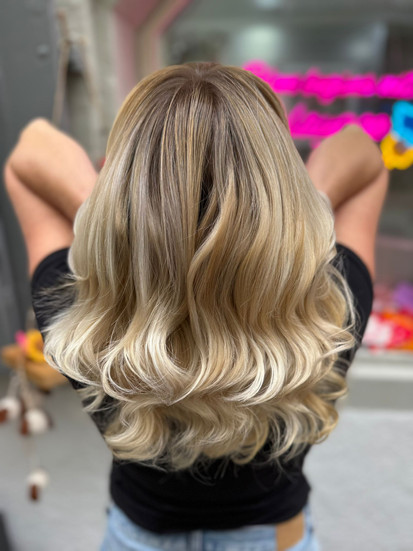 Modernes Beige-Blond Balayage mit natürlichem Ansatz und gleichmäßigen Längen, haarschonend gefärbt mit eigener Technik und Olaplex im Friseursalon in Konstanz am Bodensee, Ergebnis zeigt gesundes Haar, sanfte Wellen und ein langlebiges Blond das nur 1-2 mal jährlich aufgefrischt werden muss