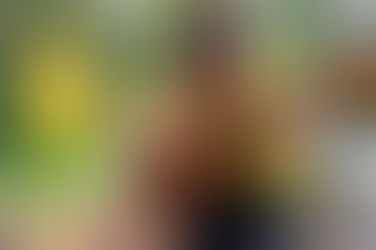 Woman playing guitar while comforting her dog outdoors.