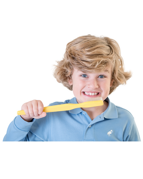 Ten year old boy pretending to brush teeth with large toothbrush