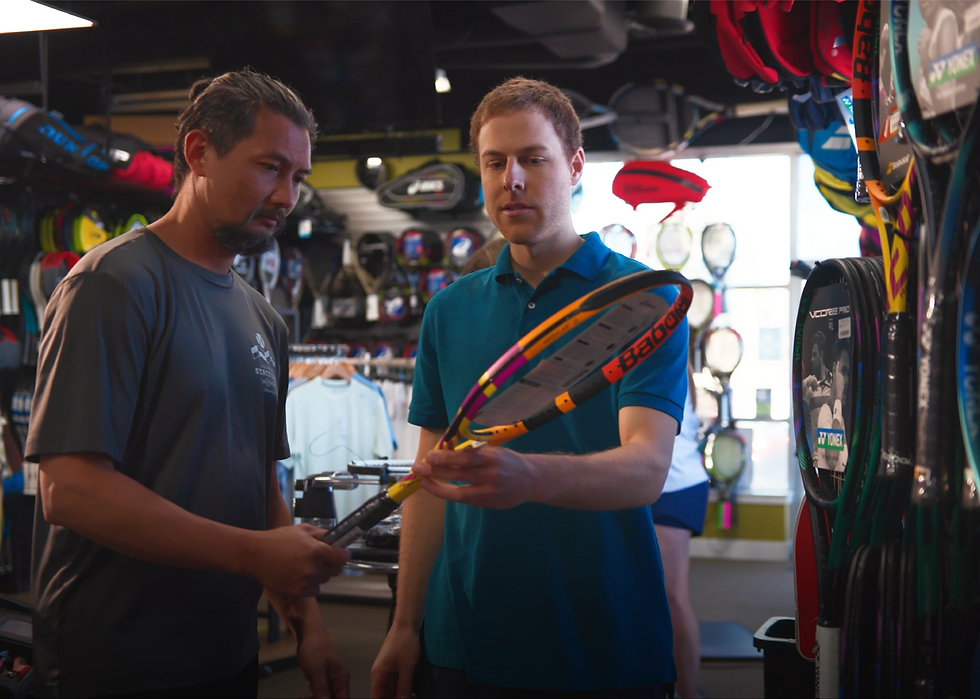 A customer being helped with racquet information in our Centennial store