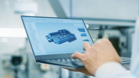 Close-up of the Engineer Holding Laptop with CAD Component Model on Screen. In the Backgro
