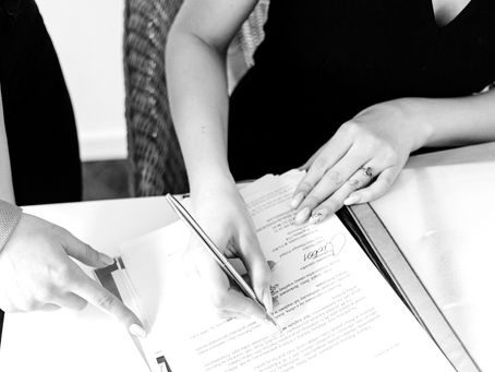 Dos personas firmando y revisando documentación para la solicitud de una patente comercial en Chile