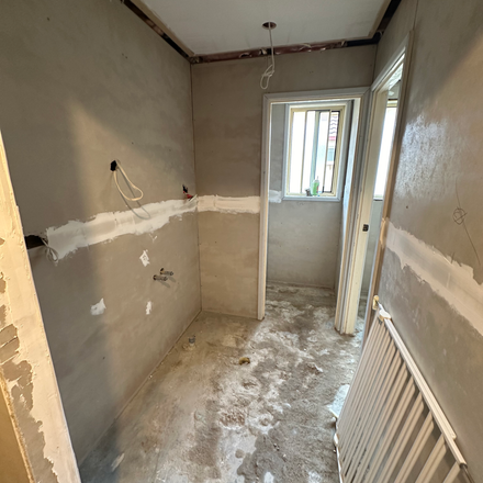 an empty room with a radiator and a window