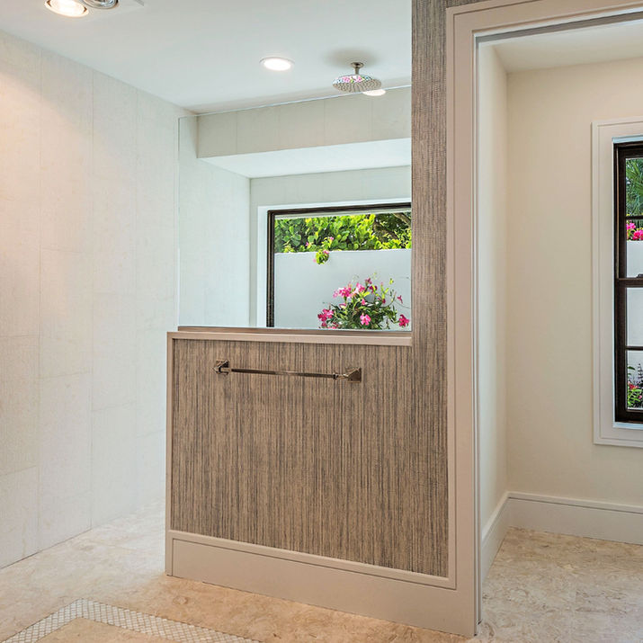 Primary bathroom with walk-in shower, garden window, gray vanity, and textured walls.