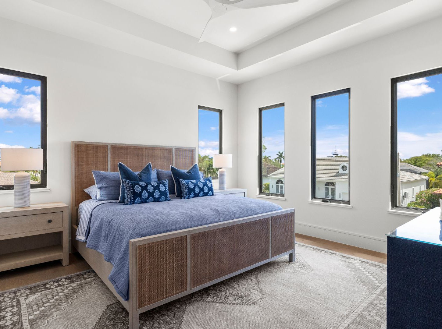 Modern bedroom with blue bedding and large windows