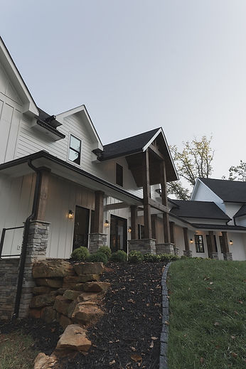Aerial drone view of a mountain modern custom home site plan in Canton, GA, showcasing a standing-seam metal roof layout and a unique 15-degree angled garage design by Reynard Architectural Designs.