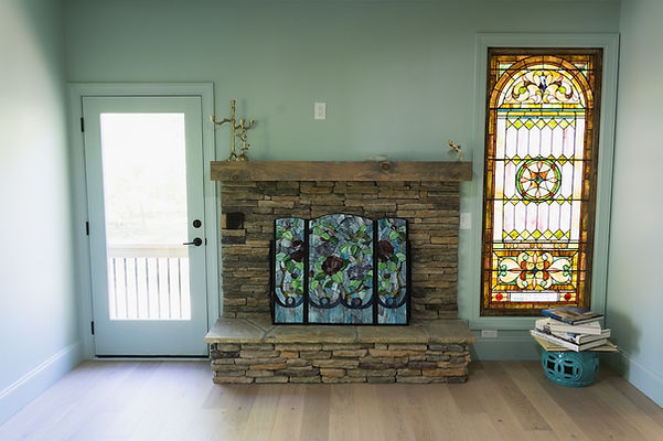 Fireplace Rivendell Hiawassee, GA - Reynard Architectural Designs. Interior shot of the living room with ornate glass and door to outside patio.