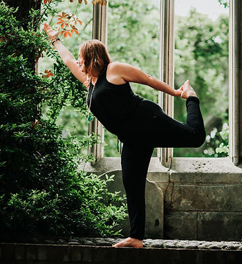 A woman practising dancer's pose (nataranjasana)