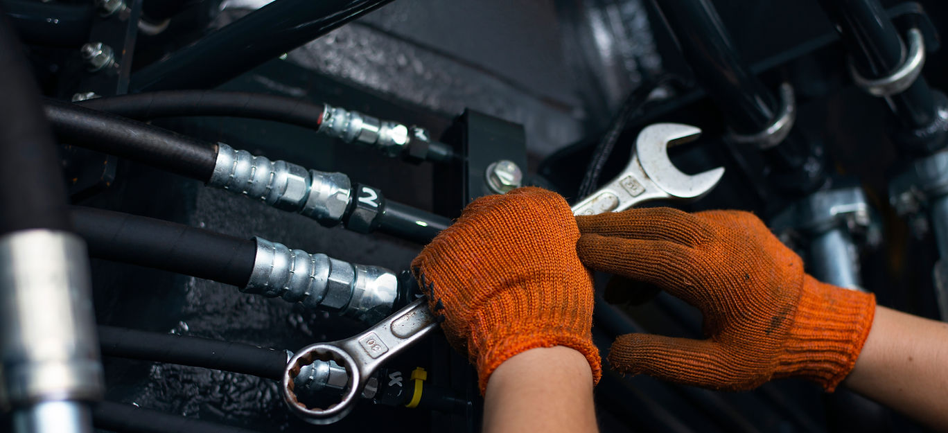 Banner with close up view of hydraulic pipes of heavy industry machine and hands of mechan