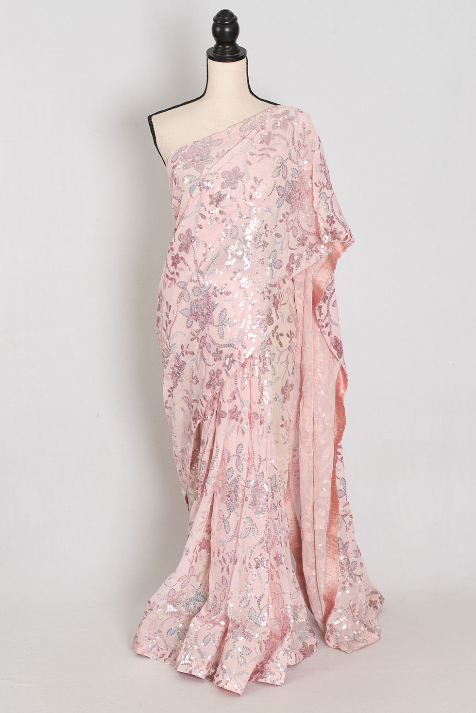 Baby pink designer soft net sequin partywear saree on a mannequin showing floral sequin embroidery.